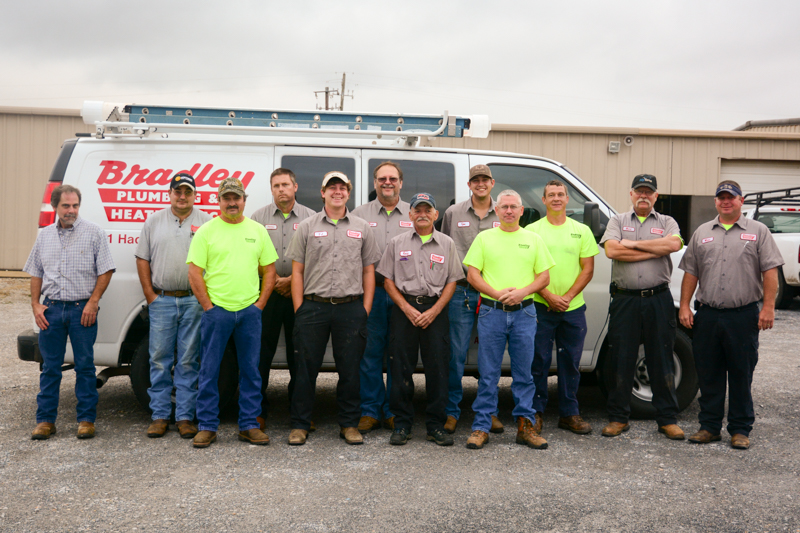 Bradley Plumbing and Heating staff in front of work van